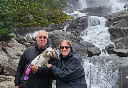 Roger and Le, the CamperBudget founders, with their dog Jolie at Langfoss waterfall, Norway